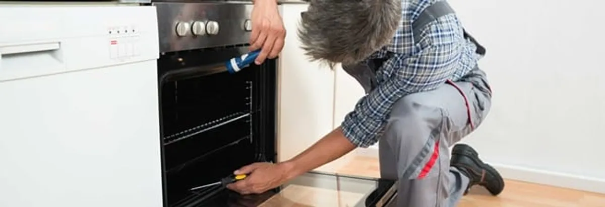 Oven repair technician inspecting and servicing an electric oven in Honolulu, HI